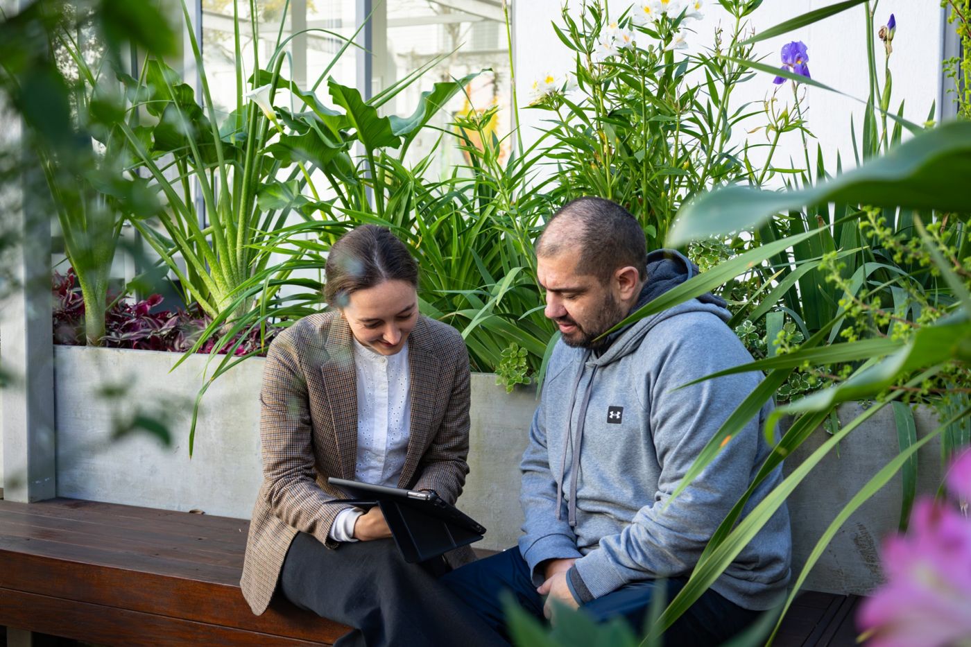 A speech therapist and a patient working together on a tablet in the garden at Faircape